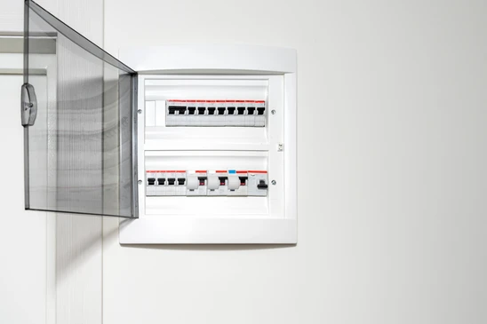 Intérieur résidentiel moderne avec tableau électrique ouvert fixé au mur blanc