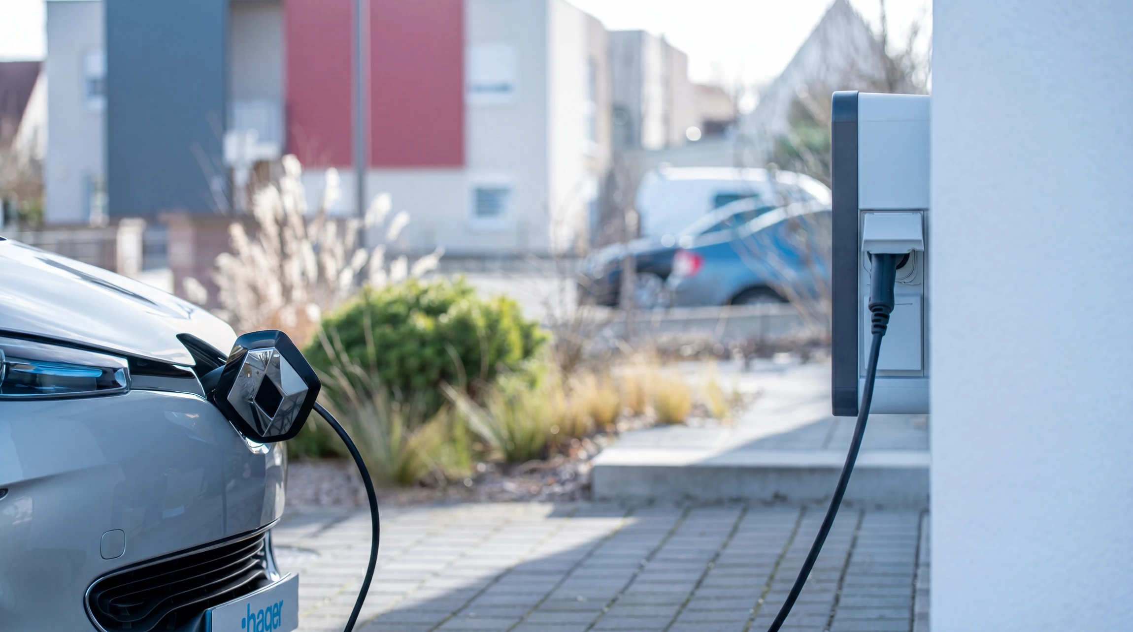 Scène extérieure ensoleillée avec véhicule électrique en cours de recharge