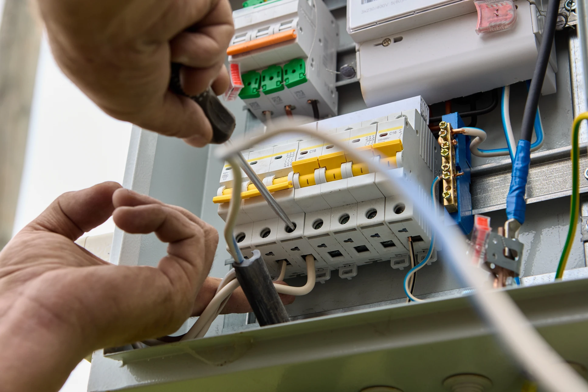 Électricien en équipement de protection individuelle travaillant sur un tableau électrique résidentiel