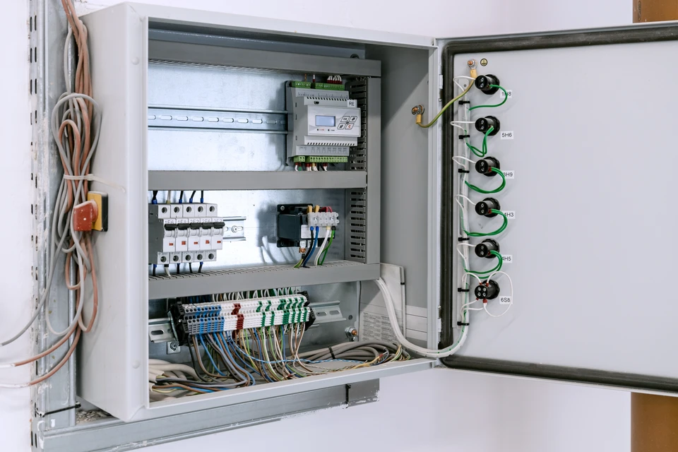 Électricien professionnel en chemise à carreaux travaillant avec des équipements électriques
