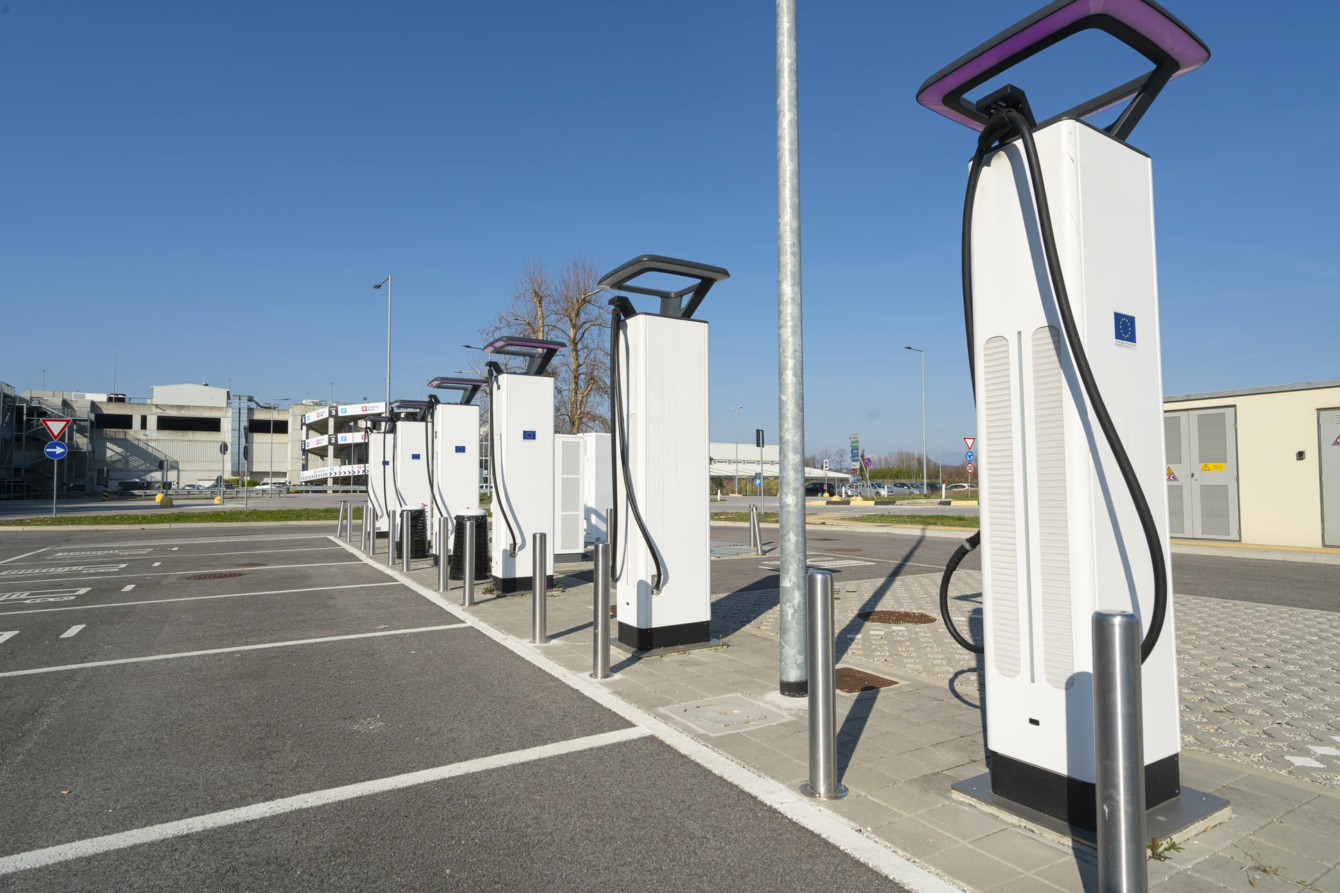 Parking extérieur ensoleillé avec plusieurs véhicules électriques en charge