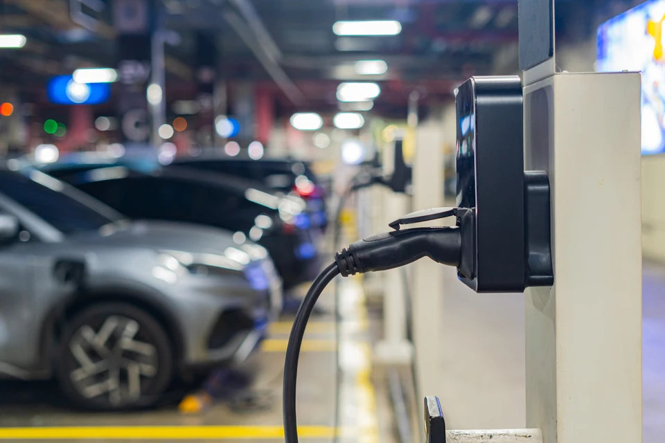 Scène extérieure urbaine avec véhicule électrique BMW i3 argenté en charge via borne de recharge publique